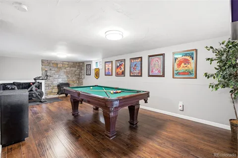 a room with furniture pool table and wooden floor