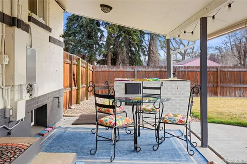 a patio with glass top table and chairs
