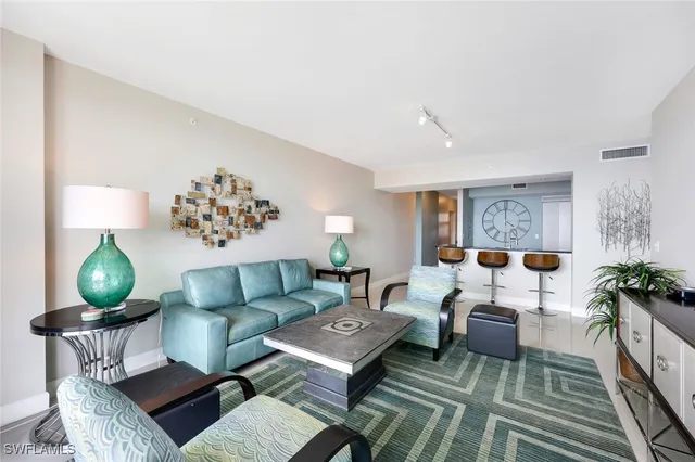 a living room with furniture a lamp and a rug