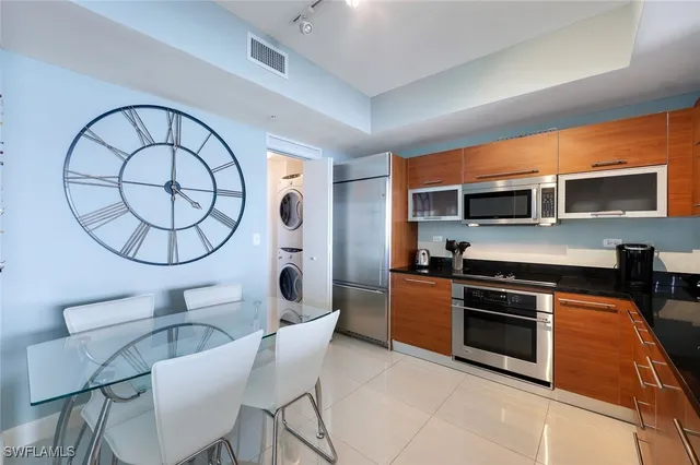 a kitchen with stainless steel appliances a stove a microwave a sink a stove and a dining table