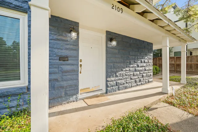 a view of front door of house with wooden fence