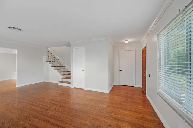 a view of an empty room with wooden floor