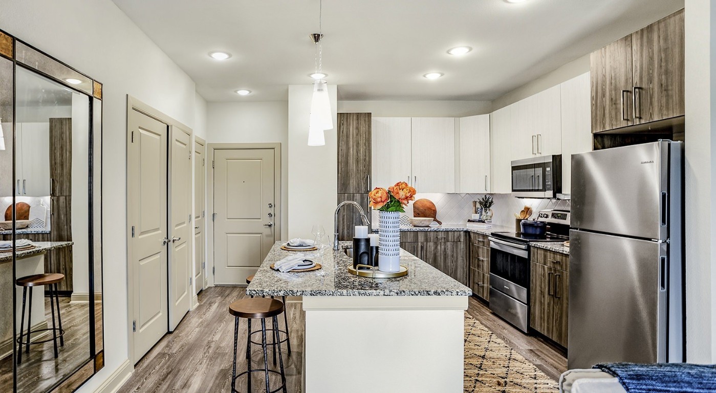 7100 Uvalde Road, Unit 7110 Houston, TX 77049 - Photo 5 of 28 a kitchen with stainless steel appliances a refrigerator stove microwave and cabinets