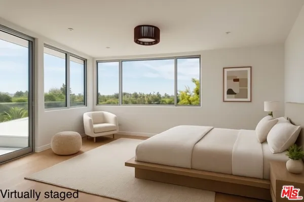 a bedroom with a bed and a large window