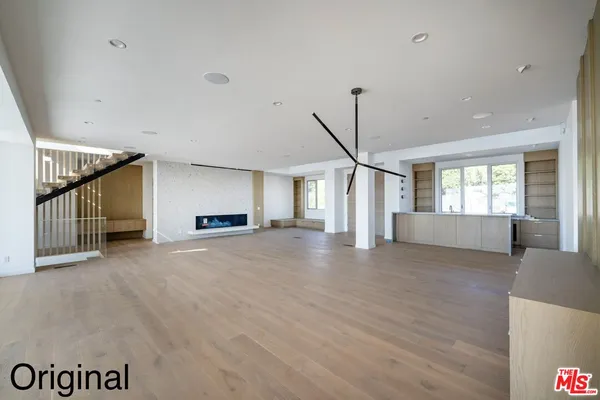 a view of an empty room with a window and fireplace