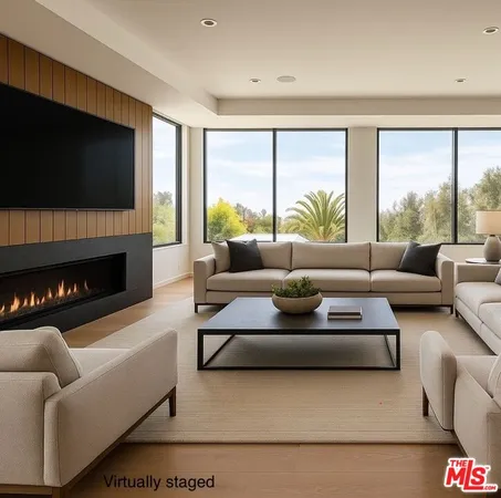 a living room with furniture a large window and a fireplace