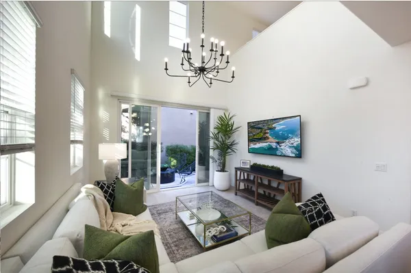 a living room with furniture a chandelier and a painting