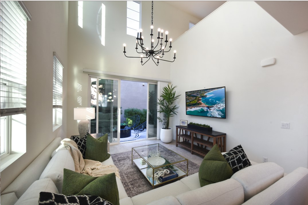 a living room with furniture a chandelier and a painting