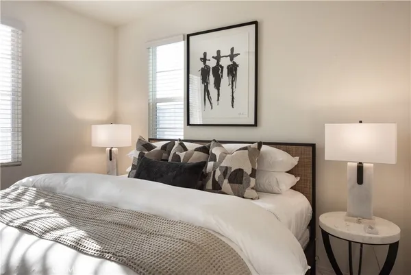 a bedroom with a bed and a painting on the wall
