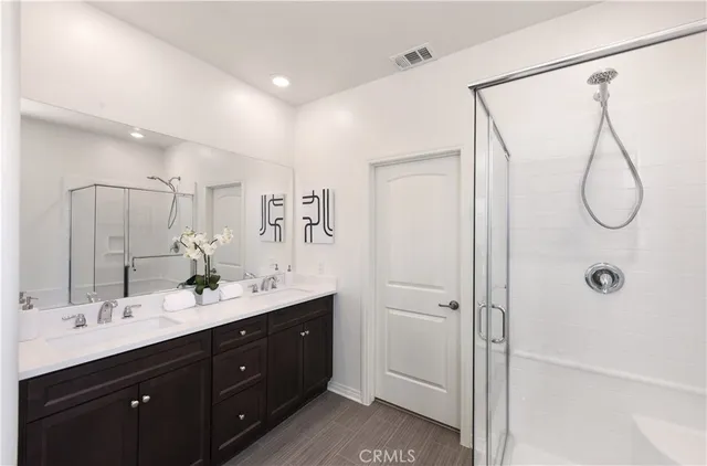a bathroom with a double vanity sink toilet mirror and shower