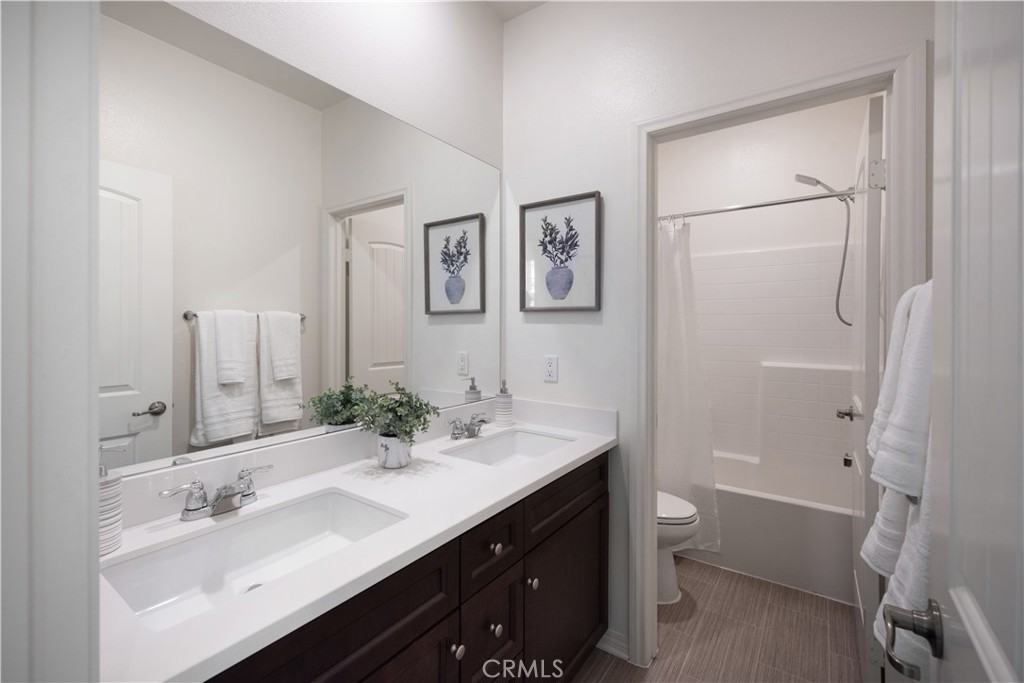 7075 Montecito Lane Eastvale, CA 92880 - Photo 25 of 26 a bathroom with a double vanity sink mirror double and tub