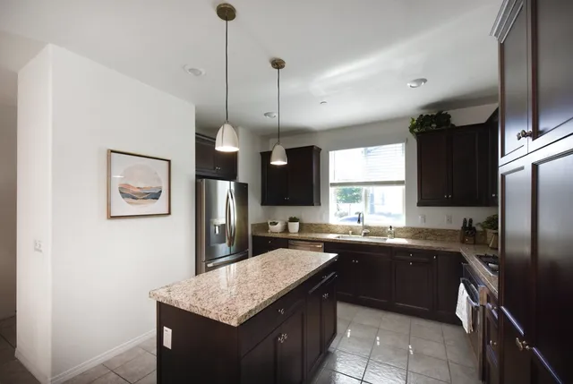 a kitchen with a sink a counter top space stainless steel appliances and cabinets