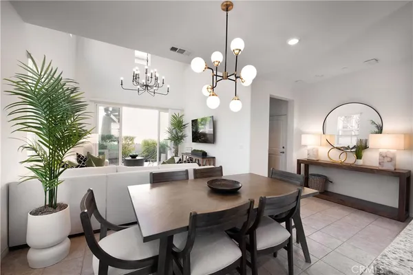 a view of a dining room with furniture a chandelier and wooden floor