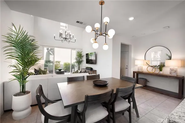 a view of a dining room with furniture a chandelier and wooden floor