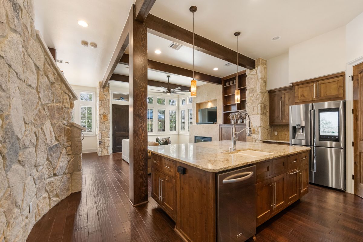 2002 Kinney Avenue, Unit A Austin, TX 78704 - Photo 11 of 26 a large kitchen with stainless steel appliances kitchen island granite countertop a large counter top and wooden floors