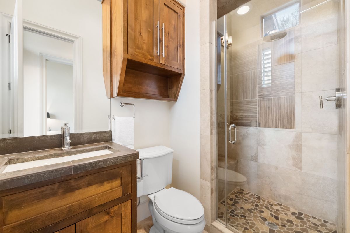 2002 Kinney Avenue, Unit A Austin, TX 78704 - Photo 21 of 26 a bathroom with a sink a toilet a mirror and shower