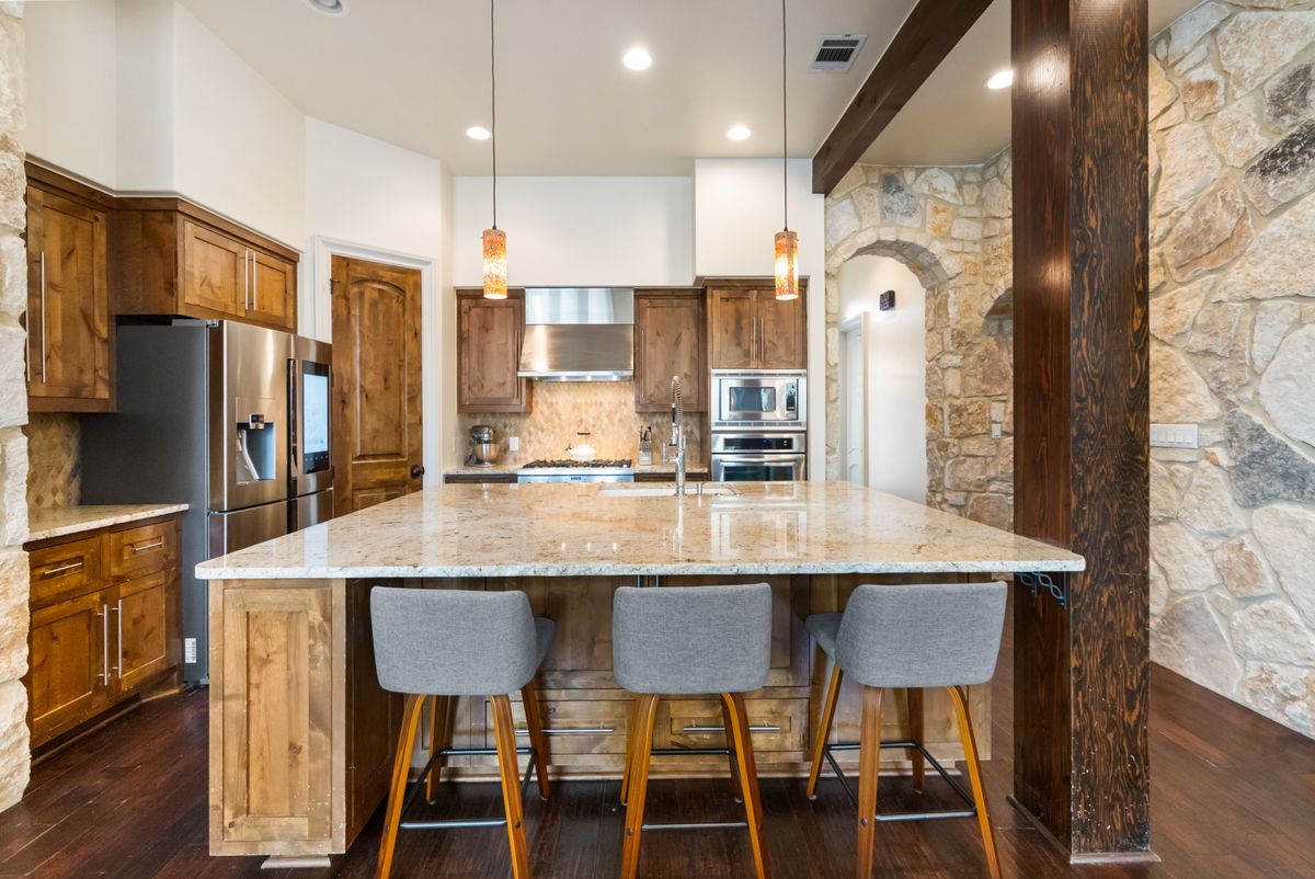 2002 Kinney Avenue, Unit A Austin, TX 78704 - Photo 8 of 26 a kitchen with stainless steel appliances granite countertop a table chairs microwave and sink