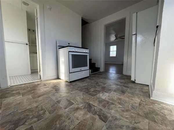 an empty room with wooden floor closet and windows