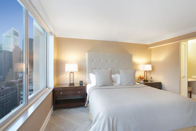 a bedroom with a bed and a large window