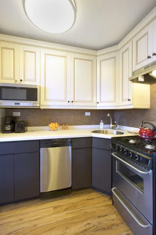 a kitchen with granite countertop wooden cabinets stainless steel appliances and a window