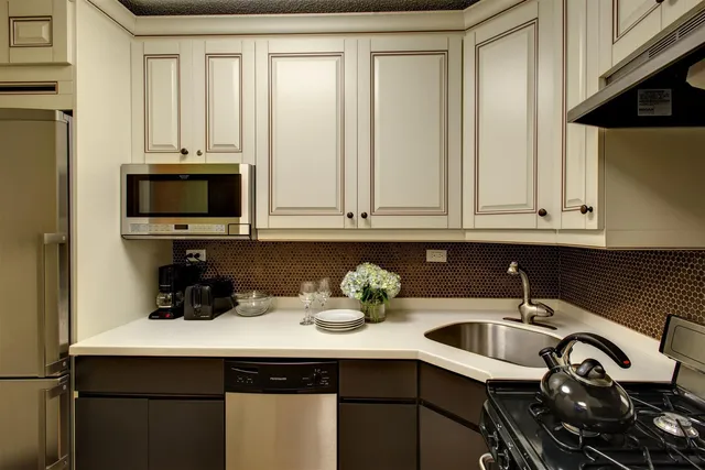 a kitchen with stainless steel appliances a sink a stove and white cabinets
