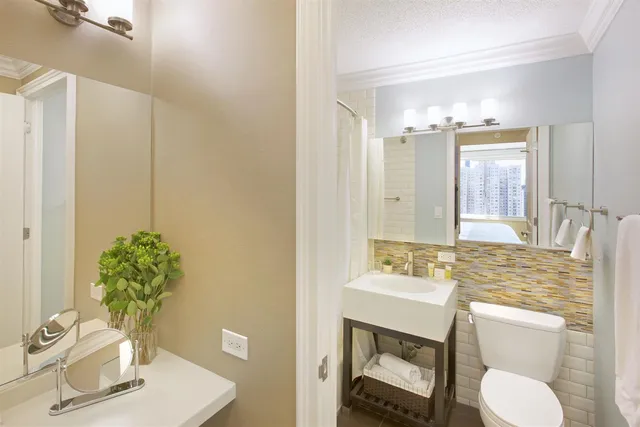 a bathroom with a toilet sink and mirror