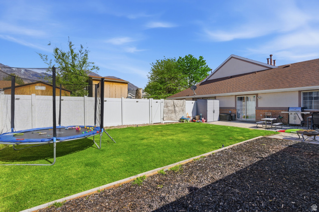 282 West 960 South, Unit C Provo, UT 84601 - Photo 29 of 33 Fenced backyard with a trampoline, a patio area, and a gate