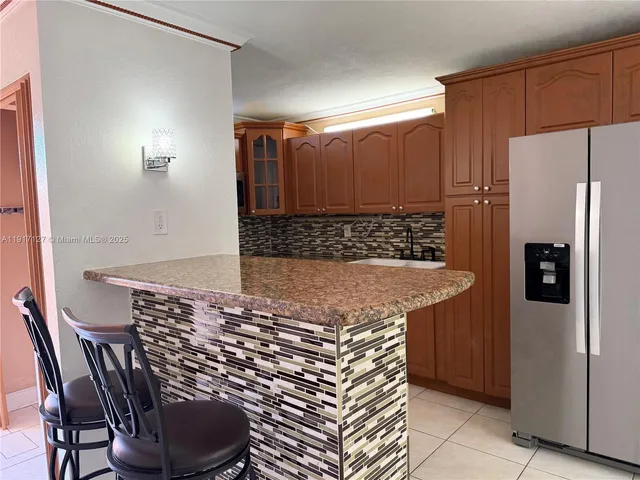 a view of kitchen with stainless steel appliances granite countertop a refrigerator and a stove