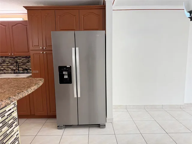 a kitchen with metallic refrigerator freezer and a dishwasher