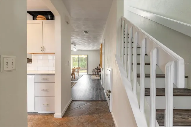 a view of a hallway with wooden floor and windows