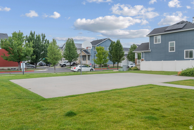 955 Delorean Lane Midvale, UT 84047 - Photo 46 of 47 Expansive green space featuring a large concrete pad, manicured lawn, and mature trees