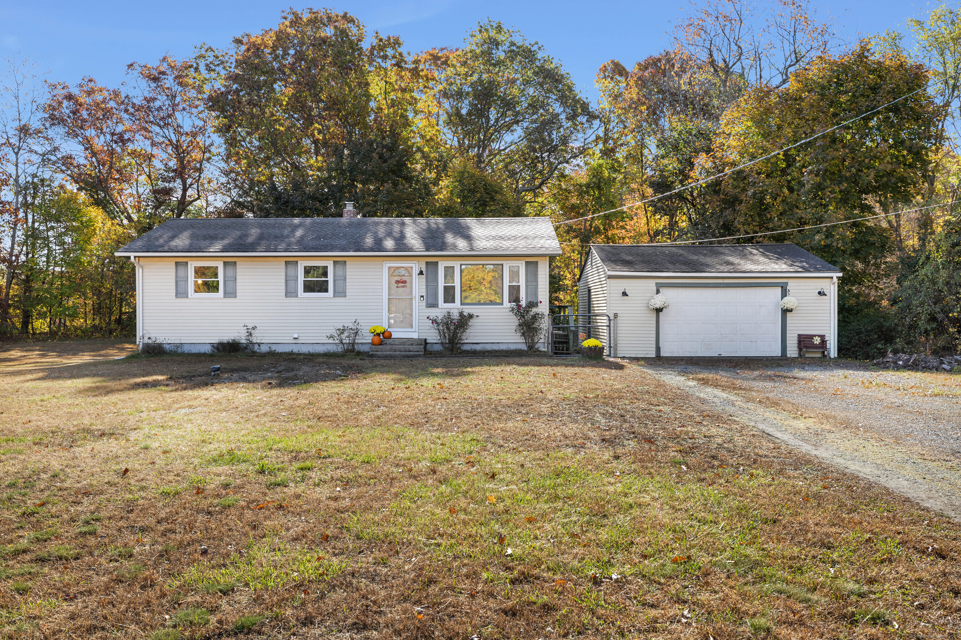 a front view of house with yard and trees in the background