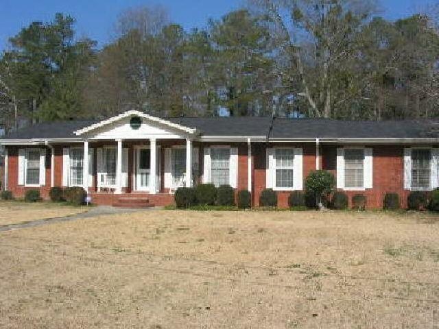 6861 South Nottingham Road Jonesboro, GA 30236 - Photo 1 of 1 a front view of a house with a garden and trees