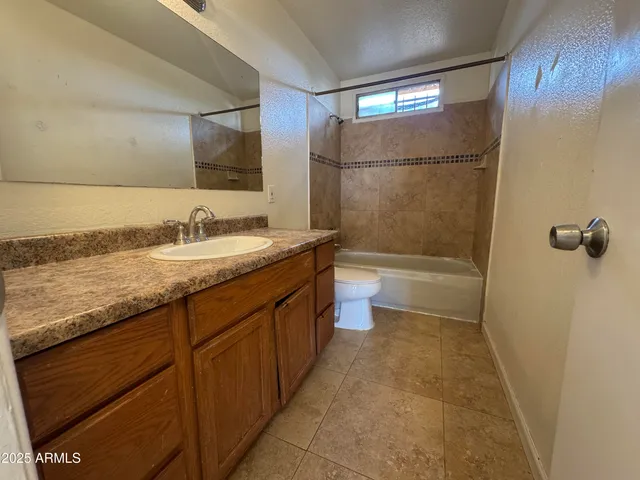 a bathroom with a granite countertop sink a toilet and shower