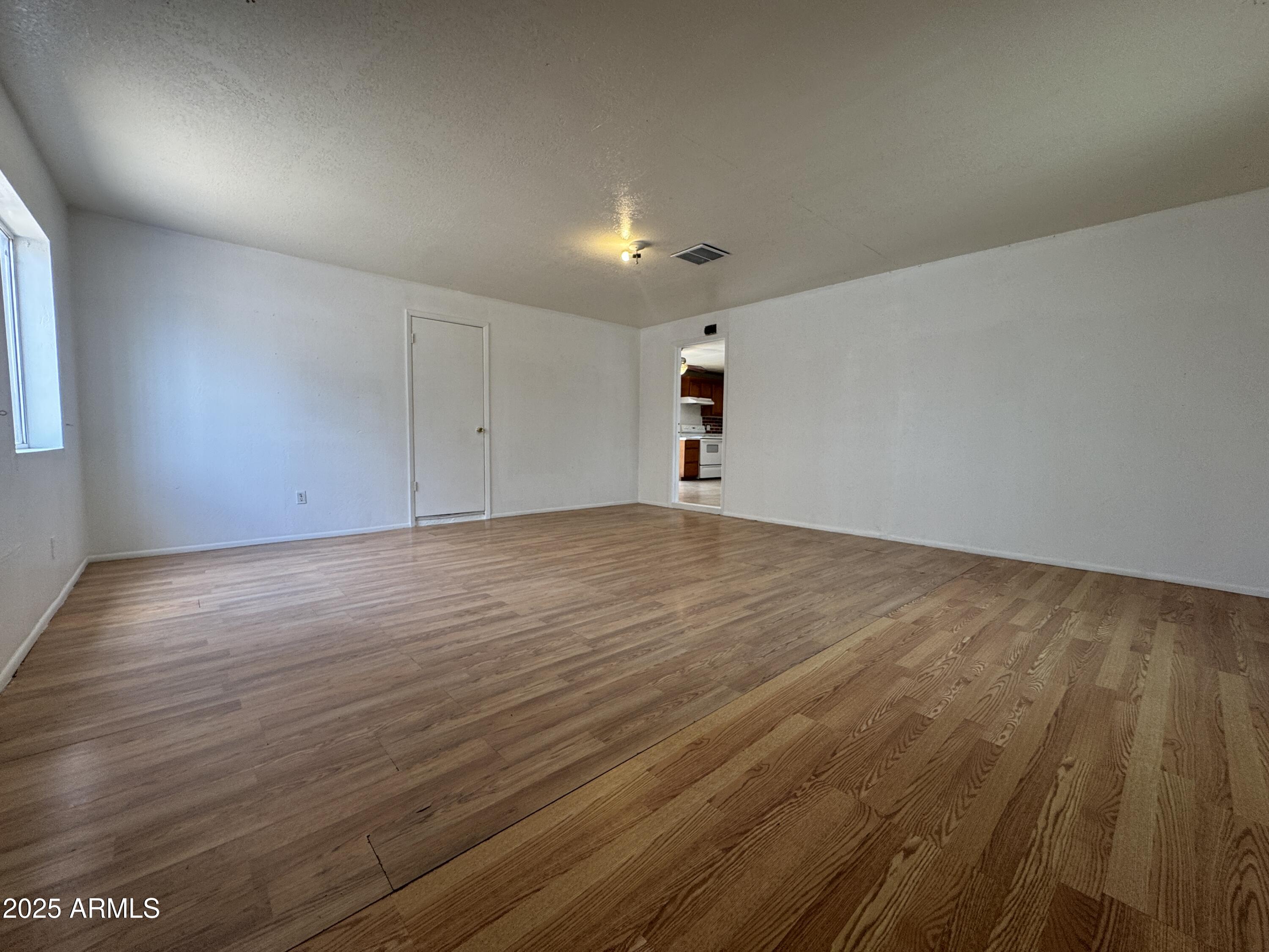 7967 West Highland Avenue Phoenix, AZ 85033 - Photo 16 of 16 an empty room with wooden floor and windows