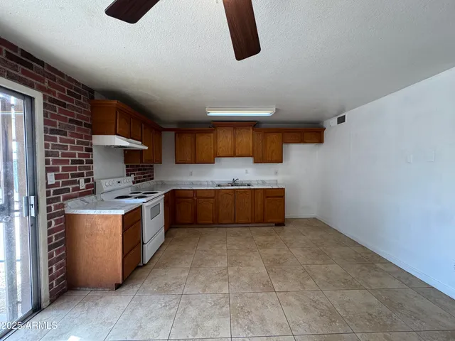 a large kitchen with stainless steel appliances granite countertop a stove a sink dishwasher and a refrigerator