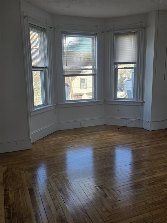 47 Webster Street, Unit 2 Lynn, MA 01902 - Photo 3 of 5 a view of an empty room with wooden floor and a window