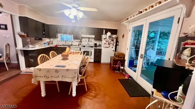 a view of a dining room with furniture a kitchen and chandelier