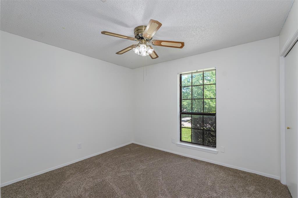 617 Rolling Ridge Court Azle, TX 76020 - Photo 8 of 20 Carpeted room featuring a ceiling fan with light fixture, a window with grid patterns, and white walls