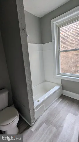 a bathroom with a toilet and a bath tub