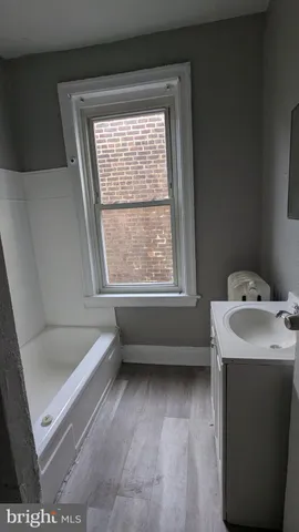 a bathroom with a tub sink and window