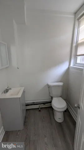 a bathroom with a sink toilet and window