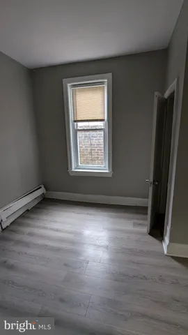 an empty room with wooden floor and a window