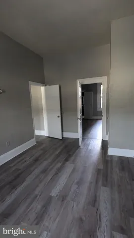 a view of empty room with wooden floor and closet
