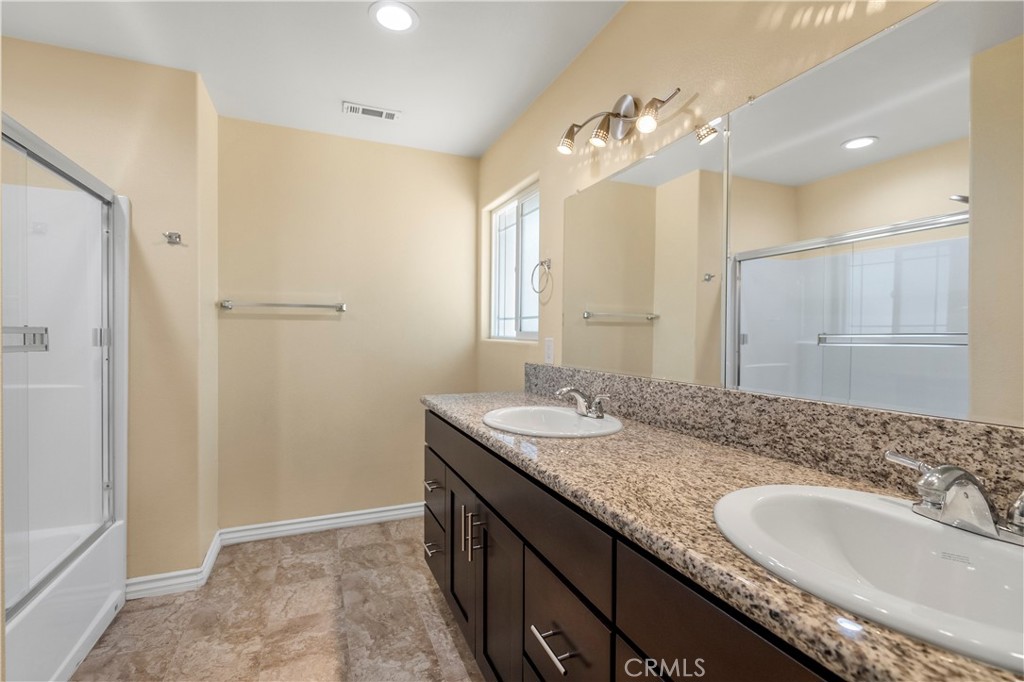 6800 Arlington Avenue Riverside, CA 92504 - Photo 14 of 25 a bathroom with a granite countertop sink a large mirror and a shower