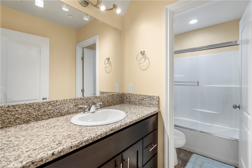6800 Arlington Avenue Riverside, CA 92504 - Photo 17 of 25 a bathroom with a granite countertop sink a toilet and shower