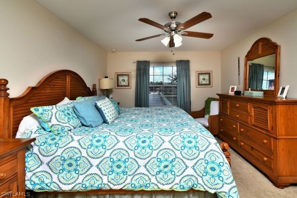 11698 Eros Road Lehigh Acres, FL 33971 - Photo 17 of 34 a bedroom with a bed mirror on dresser and a chandelier