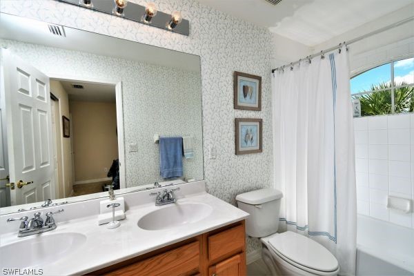 11698 Eros Road Lehigh Acres, FL 33971 - Photo 21 of 34 a bathroom with a sink vanity mirror and toilet