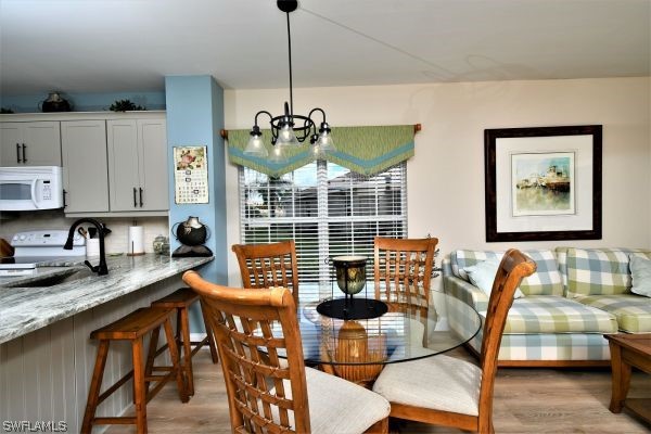 11698 Eros Road Lehigh Acres, FL 33971 - Photo 8 of 34 a kitchen with stainless steel appliances granite countertop a table and chairs in it