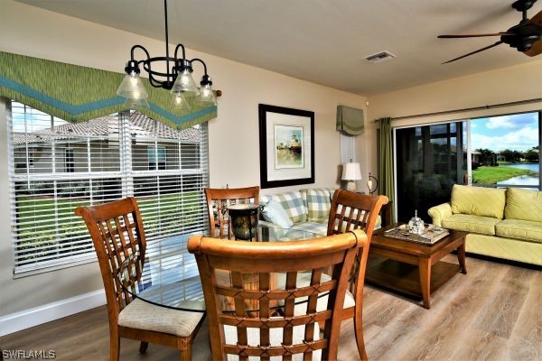 11698 Eros Road Lehigh Acres, FL 33971 - Photo 9 of 34 a dining room with furniture a chandelier and wooden floor